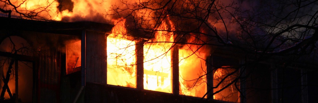 Övertänt hus med stora lågor.