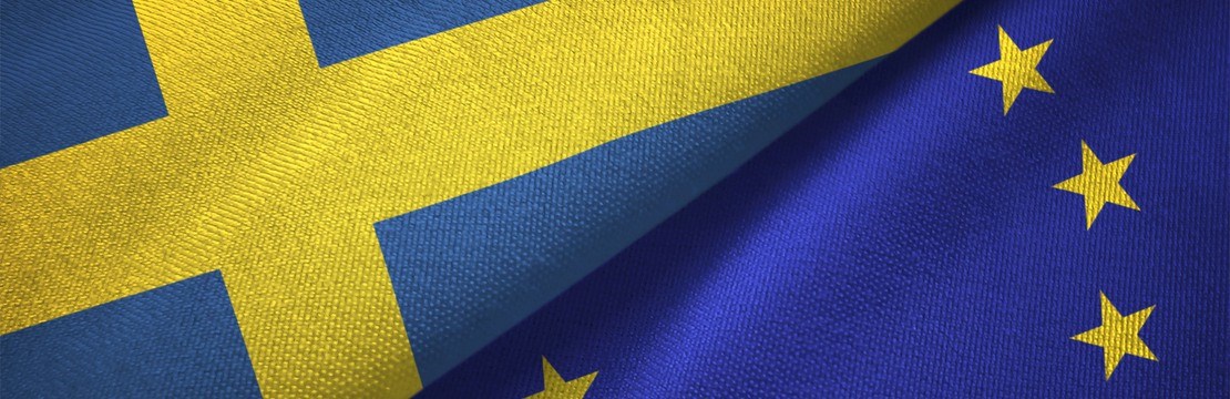 Sveriges flagga och EU-flaggan liggandes tätt ihop.  