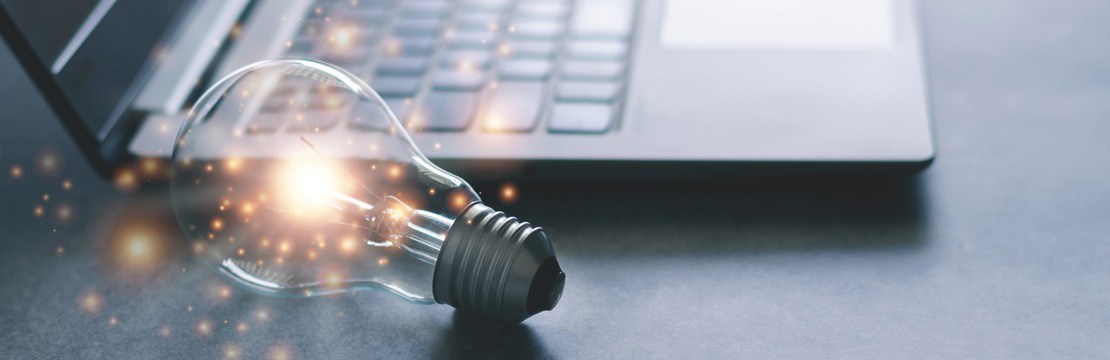 Glödlampa lyser bredvid tangentbordet på en laptop.
