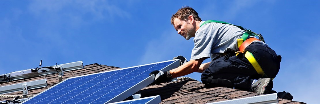 Elinstallatör monterar solcellspaneler på tak