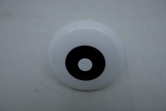 Vit nattlampa i plast med en svart ring i mitten